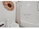 Clean bathroom featuring a toilet, shower/tub combo with white tile and unique flower wall decor at 3681 S Rosecrest Cir, Las Vegas, NV 89121