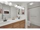 Bathroom featuring dual sinks, white cabinets, and a tub at 3681 S Rosecrest Cir, Las Vegas, NV 89121