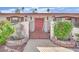 Charming front entrance with a decorative gate, colorful foliage, and unique lighting fixtures enhancing curb appeal at 3681 S Rosecrest Cir, Las Vegas, NV 89121