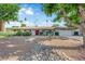 Charming single-story home with a rockscaped front yard, mature trees, and double red door at 3681 S Rosecrest Cir, Las Vegas, NV 89121