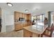 Bright kitchen with granite counters, wood cabinets, tile floors, and breakfast bar at 3681 S Rosecrest Cir, Las Vegas, NV 89121