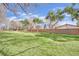 View of a large grassy lot of land covered with grass, lined with mature trees at 3681 S Rosecrest Cir, Las Vegas, NV 89121