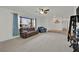 Bright living room featuring plush carpeting, large windows, a ceiling fan, and ample space for comfortable seating at 3681 S Rosecrest Cir, Las Vegas, NV 89121