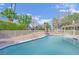 Refreshing in-ground pool surrounded by lush green landscaping and secure fencing at 3681 S Rosecrest Cir, Las Vegas, NV 89121