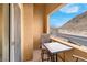 Cozy balcony setup with a table, chairs, and views of the mountain at 3975 N Hualapai Way # 235, Las Vegas, NV 89129