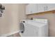Well-equipped laundry room with white washer, dryer, and storage cabinets at 3975 N Hualapai Way # 235, Las Vegas, NV 89129