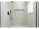 Modern glass-door shower with white tile walls, black fixtures, and a built-in shelf at 401 Lacy Ln, Las Vegas, NV 89107