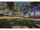 Expansive green common area with mature trees and blue sky background at 4032 Great Plains Way, Las Vegas, NV 89121