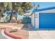 Charming home featuring a blue garage door, complemented by trees and a well-maintained yard at 4032 Great Plains Way, Las Vegas, NV 89121