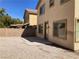 View of the gravel backyard and patio with block wall and two-story home exterior at 405 Center Green Dr, Las Vegas, NV 89148