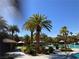 Community pool area with palm trees, cabanas, and clear blue water, perfect for relaxation and recreation at 405 Center Green Dr, Las Vegas, NV 89148