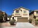 Two-story stucco home with an attached garage, manicured landscaping and a concrete driveway at 405 Center Green Dr, Las Vegas, NV 89148