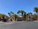 Entrance to The Collection neighborhood, lined with palm trees and featuring well-maintained landscaping at 405 Center Green Dr, Las Vegas, NV 89148