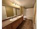 Bathroom with a double sink vanity, large mirror, and a shower-tub combo at 45 Maleena Mesa St # 1921, Henderson, NV 89074