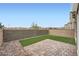 Cozy backyard featuring a brick patio, artificial grass, rock landscaping, and a privacy wall at 4727 Agave Cactus St, North Las Vegas, NV 89031