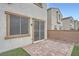 Small backyard with brick patio, artificial grass, and privacy wall, creating a cozy outdoor space at 4727 Agave Cactus St, North Las Vegas, NV 89031
