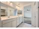 Bathroom with double sinks, large mirrors and ample lighting in a modern and sleek design at 4727 Agave Cactus St, North Las Vegas, NV 89031
