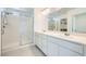Bathroom with double sinks, quartz counters, and a glass-enclosed shower at 4727 Agave Cactus St, North Las Vegas, NV 89031