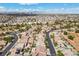Extensive aerial view of a community with many pools, tile roofs, and mountain views at 5577 Golden Leaf Ave, Las Vegas, NV 89122