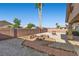 A backyard featuring a fire pit, desert landscaping, a brick wall, and palm trees at 5577 Golden Leaf Ave, Las Vegas, NV 89122