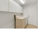 This laundry room features overhead cabinets, washer and dryer and tile floors at 5577 Golden Leaf Ave, Las Vegas, NV 89122
