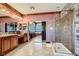 Spacious bathroom featuring double vanities, walk-in shower, and soaking tub visible through mirrors at 7210 El Malpais St, Las Vegas, NV 89118