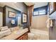 Nicely decorated bathroom features decorative tile, framed art, tub, and vanity with towels and plants at 7210 El Malpais St, Las Vegas, NV 89118