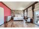 Bright bedroom with stone accent wall, wood floors, and access to a private balcony at 7210 El Malpais St, Las Vegas, NV 89118