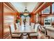 Elegant dining room featuring wood paneling, a fireplace, and a large table with seating for eight at 7210 El Malpais St, Las Vegas, NV 89118