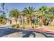 Beautiful home exterior with a three-car garage, stone accents, and lush landscaping with palm trees at 7210 El Malpais St, Las Vegas, NV 89118