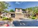 Attractive two-story house featuring a three-car garage, front yard, and beautiful landscaping at 7210 El Malpais St, Las Vegas, NV 89118
