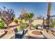 Seating area with a fire pit surrounded by beautiful landscaping and greenery at 7210 El Malpais St, Las Vegas, NV 89118