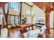 Spacious living room with a pool table, hardwood floors, high ceilings, and large windows at 7210 El Malpais St, Las Vegas, NV 89118