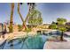 Swimming pool featuring a rock waterfall, jacuzzi and lush landscaping at 7210 El Malpais St, Las Vegas, NV 89118