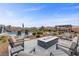 Backyard with modern outdoor seating surrounding a mosaic tile fire pit, with pool and playset in the background at 7277 W Landberg Ave, Las Vegas, NV 89178