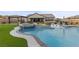 A backyard oasis featuring a pool with spa, built-in loungers, outdoor kitchen and manicured landscaping at 7277 W Landberg Ave, Las Vegas, NV 89178
