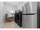 Well-equipped laundry room featuring a modern washer, dryer, and stainless steel refrigerator at 7277 W Landberg Ave, Las Vegas, NV 89178