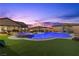Inviting backyard pool and spa featuring a slide and pristine landscaping enhanced by a colorful twilight sky at 7277 W Landberg Ave, Las Vegas, NV 89178
