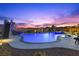 Backyard pool with a slide and playset, aglow under the vibrant colors of dusk at 7277 W Landberg Ave, Las Vegas, NV 89178