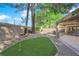 Backyard putting green is surrounded by mature shade trees at 7368 Mission Hills Dr, Las Vegas, NV 89113