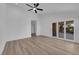 Bright bedroom with wood floors, ceiling fan, and sliding glass doors leading to a patio or balcony at 7368 Mission Hills Dr, Las Vegas, NV 89113