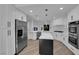 Kitchen with stainless steel fridge, marble counters, island, and white cabinets at 7368 Mission Hills Dr, Las Vegas, NV 89113