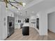 Open kitchen layout featuring stainless steel appliances, quartz counters, island, and modern light fixture at 7368 Mission Hills Dr, Las Vegas, NV 89113