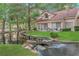 The yard features a tranquil stream flowing through a lush green landscape at 7368 Mission Hills Dr, Las Vegas, NV 89113