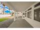 A wide shot of the covered back patio with exterior white walls, a tidy lawn, and a bright sunny atmosphere at 7464 Forestdale Ct, Las Vegas, NV 89120