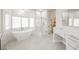 Modern bathroom featuring a soaking tub, glass shower, vanity, and bright natural light at 7464 Forestdale Ct, Las Vegas, NV 89120
