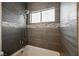 Modern bathroom with a tiled shower-tub and a bright window at 7464 Forestdale Ct, Las Vegas, NV 89120