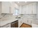 Modern kitchen featuring white cabinets, stainless steel appliances, and elegant quartz countertops at 7464 Forestdale Ct, Las Vegas, NV 89120