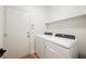 Neat laundry room with modern washer and dryer and functional shelf at 7464 Forestdale Ct, Las Vegas, NV 89120