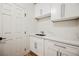A clean, bright mud room featuring white cabinets and quartz countertops at 7464 Forestdale Ct, Las Vegas, NV 89120
